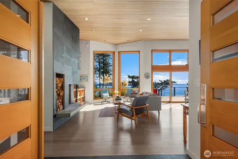 a living room with fireplace furniture and a large window