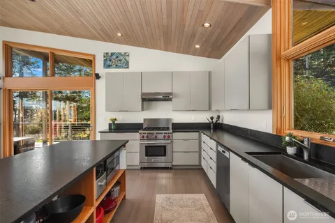 a kitchen with stainless steel appliances granite countertop a sink a stove and a refrigerator