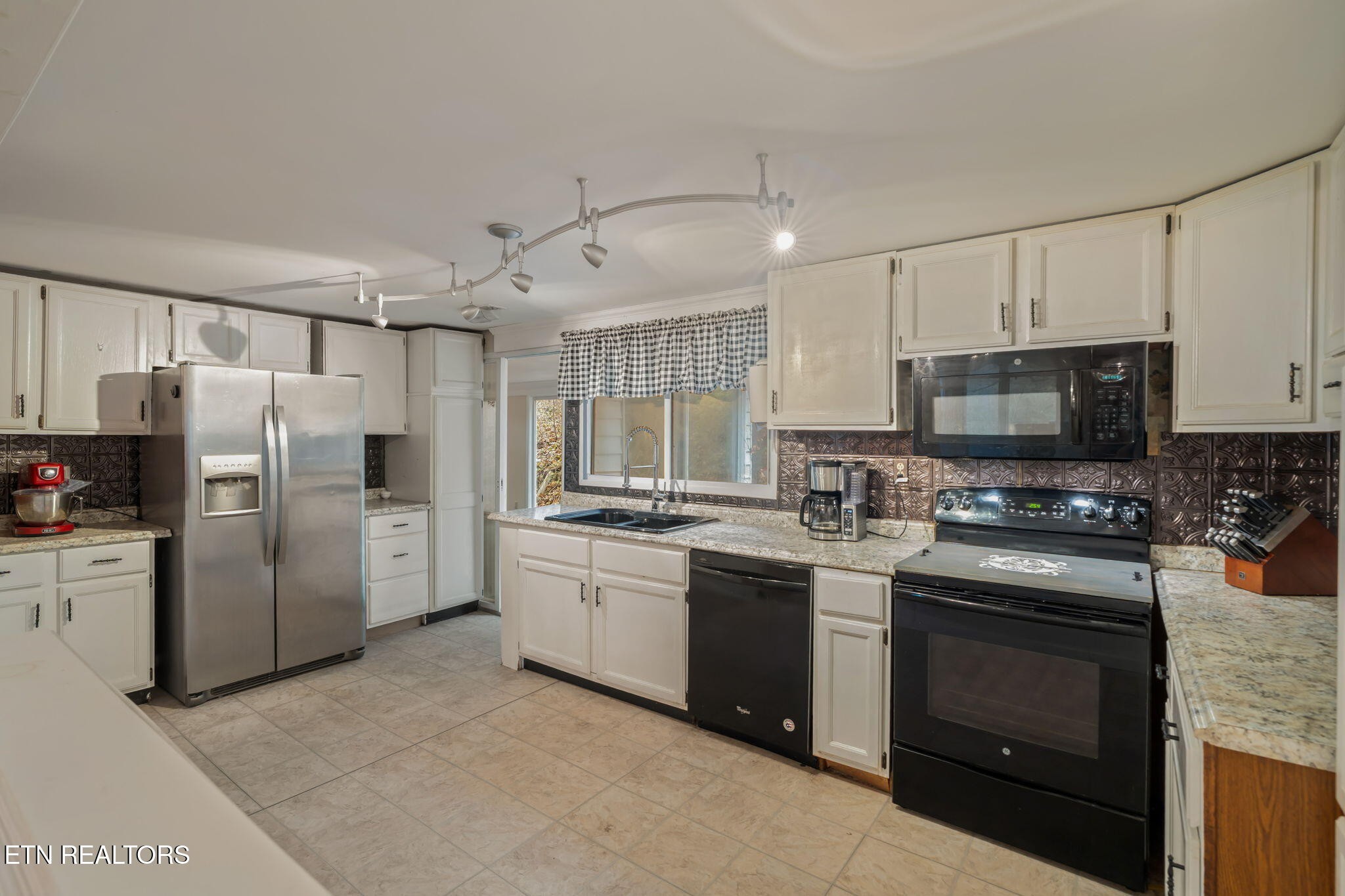 8404 Brickyard Road Powell, TN 37849 - Photo 21 of 49 a kitchen with stainless steel appliances granite countertop a stove a sink and a refrigerator