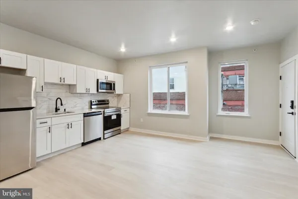 a large kitchen with granite countertop a stove a sink dishwasher and a refrigerator