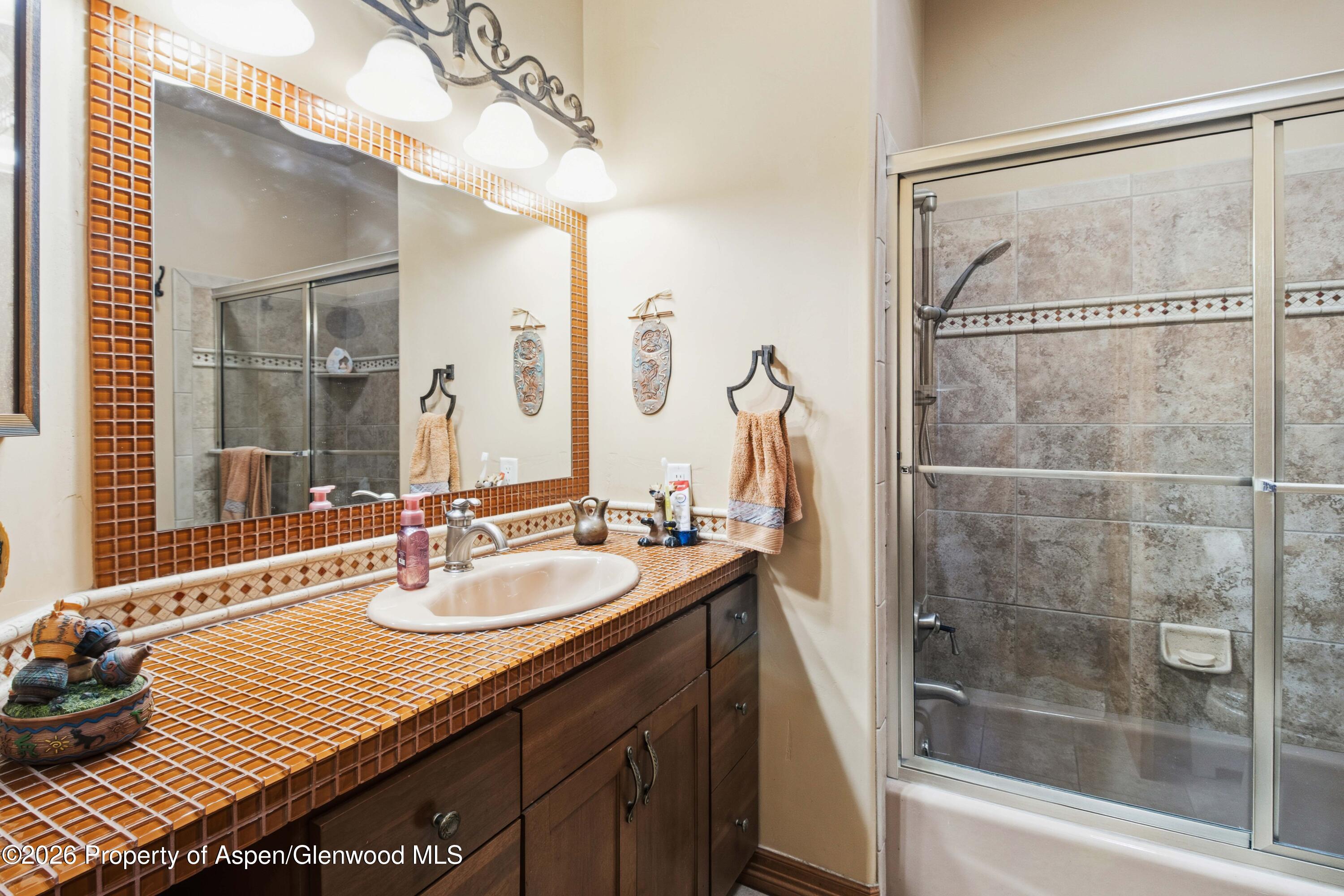 71 River View Place Parachute, CO 81635 - Photo 28 of 45 a bathroom with a sink and a mirror with bathtub