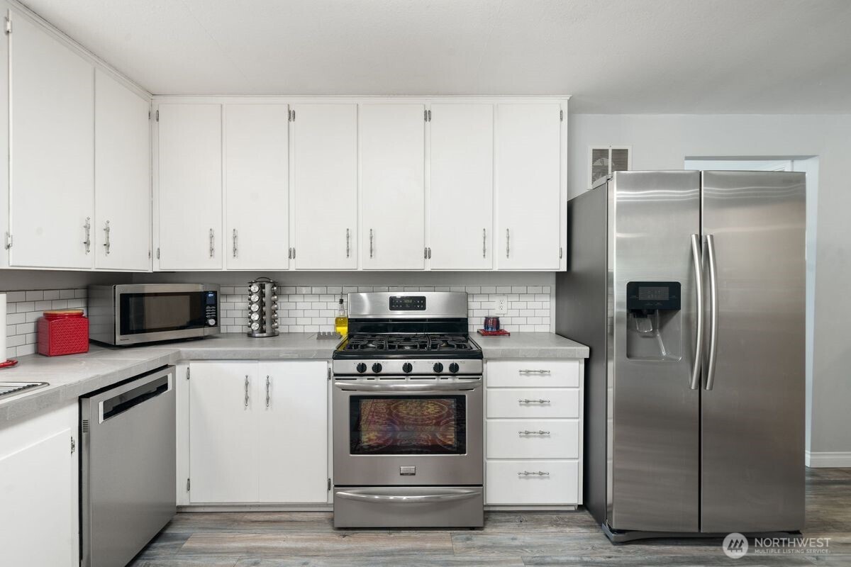 560 Mountain Trail Road Brinnon, WA 98320 - Photo 8 of 40 a kitchen with white cabinets and stainless steel appliances