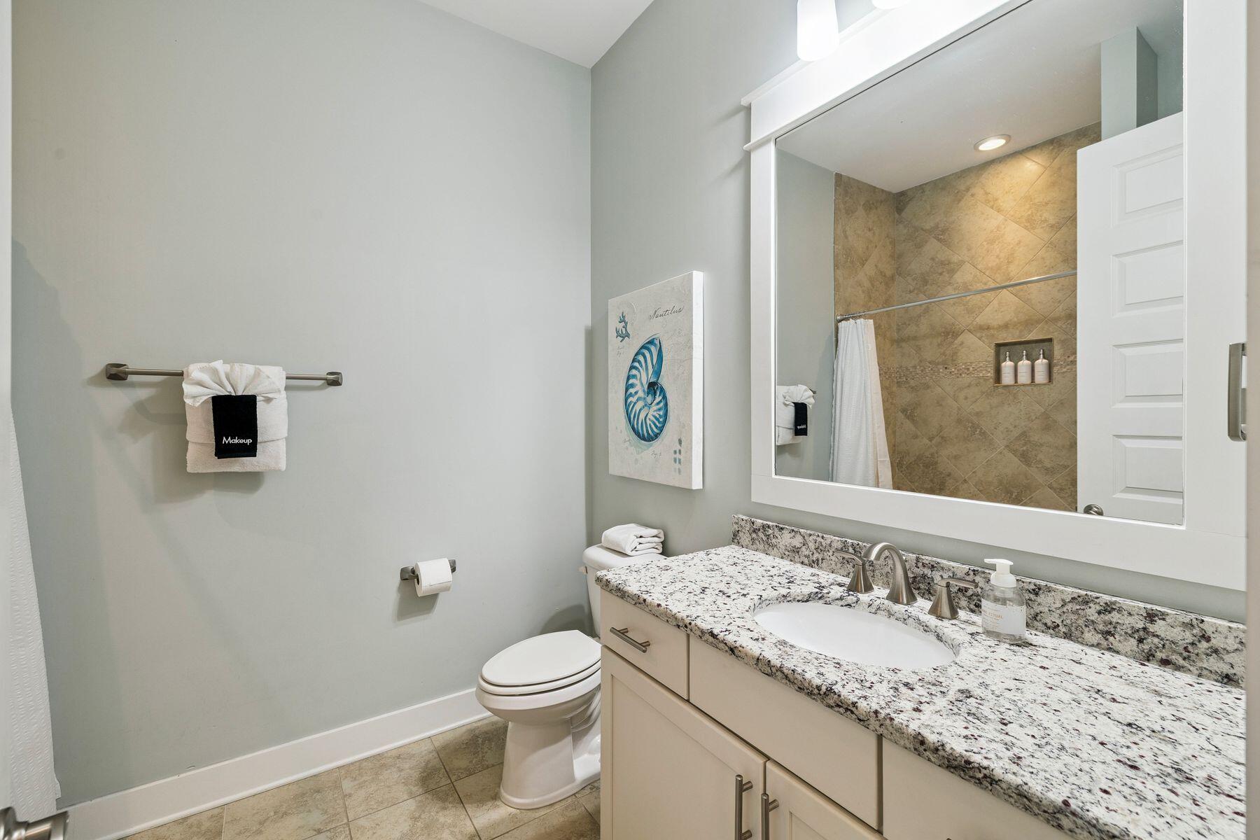 167 Milestone Drive, Unit A Inlet Beach, FL 32461 - Photo 20 of 29 a bathroom with a granite countertop sink toilet and mirror