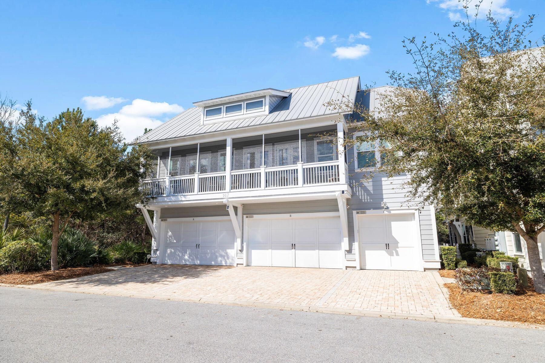 167 Milestone Drive, Unit A Inlet Beach, FL 32461 - Photo 3 of 29 a front view of a house with a garden and garage