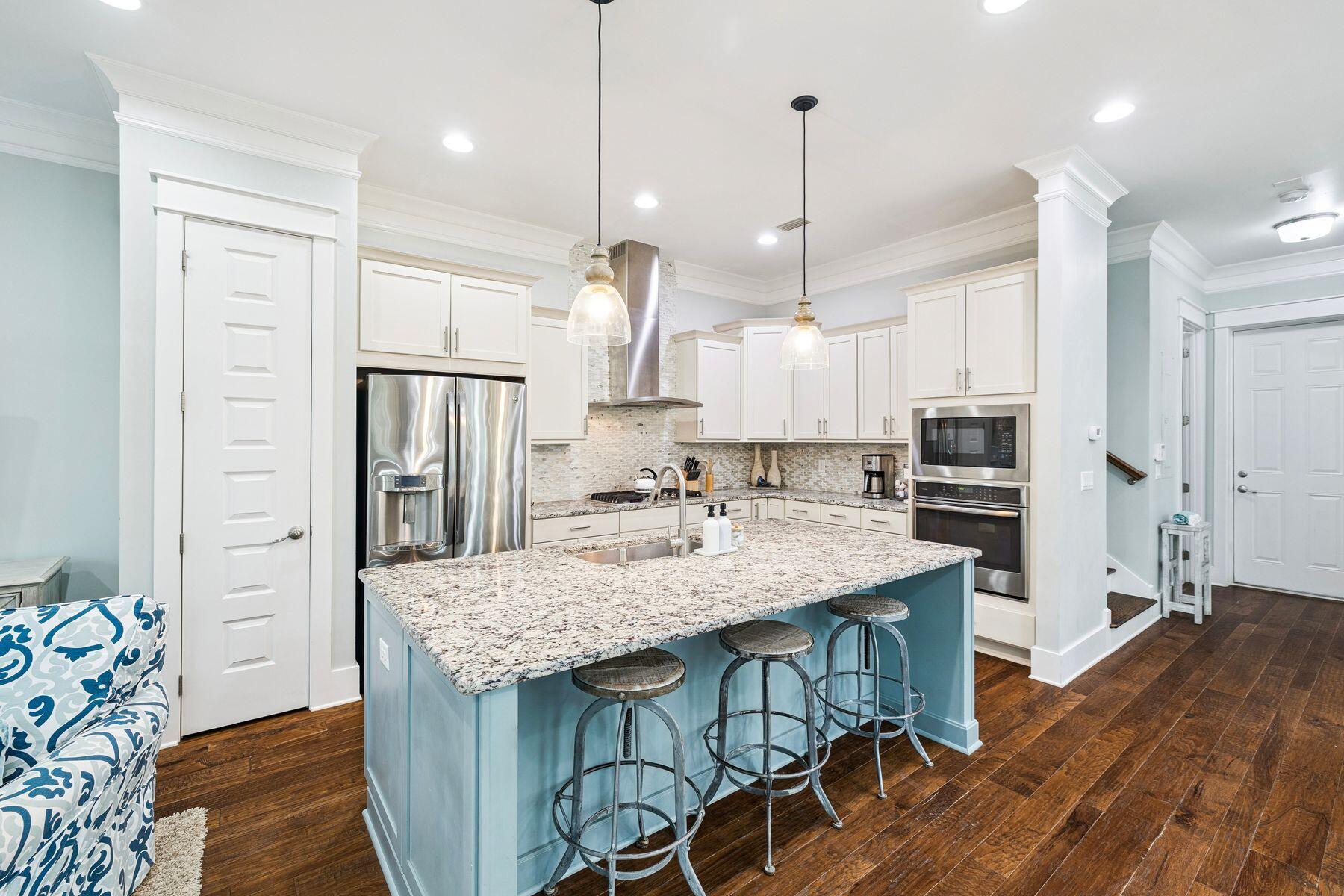 167 Milestone Drive, Unit A Inlet Beach, FL 32461 - Photo 4 of 29 a kitchen with stainless steel appliances granite countertop a kitchen island a stove a refrigerator a oven a sink with island and chairs