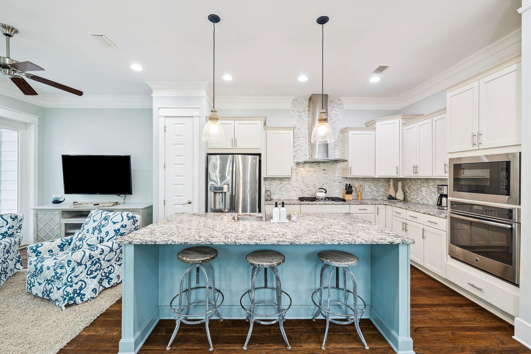 167 Milestone Drive, Unit A Inlet Beach, FL 32461 - Photo 6 of 29 a kitchen with stainless steel appliances granite countertop a stove a sink a microwave a refrigerator and chairs