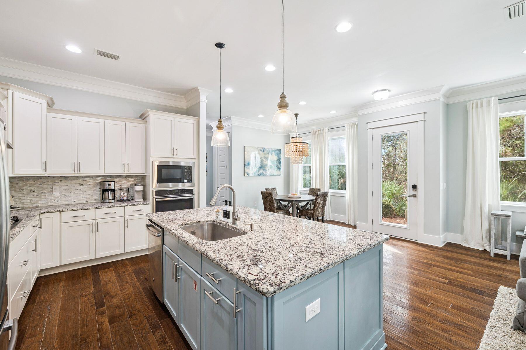 167 Milestone Drive, Unit A Inlet Beach, FL 32461 - Photo 7 of 29 a kitchen with center island wooden floor center island and stainless steel appliances