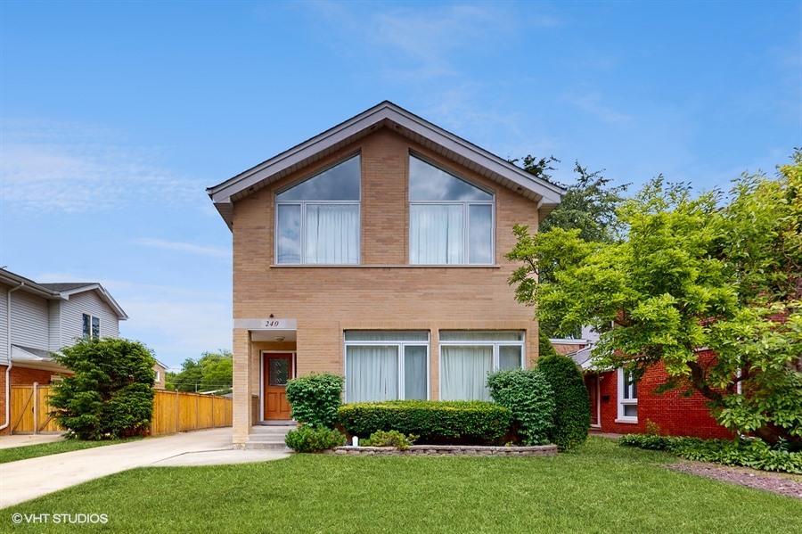 a front view of house with yard and green space