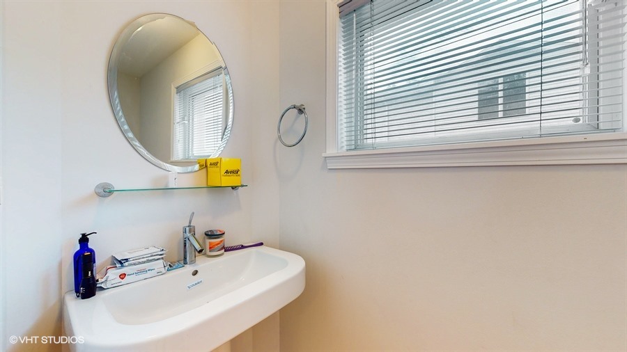 240 Hibbard Road Wilmette, IL 60091 - Photo 14 of 42 a bathroom with a sink and a mirror