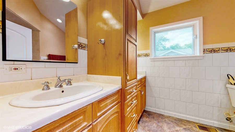 240 Hibbard Road Wilmette, IL 60091 - Photo 28 of 42 a bathroom with a sink and a mirror
