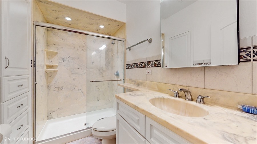 240 Hibbard Road Wilmette, IL 60091 - Photo 33 of 42 a bathroom with a granite countertop sink a toilet and shower