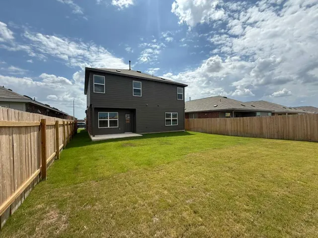 a view of a house with a yard and a large tree