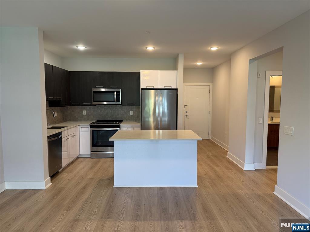 a large kitchen with stainless steel appliances granite countertop a stove and a refrigerator