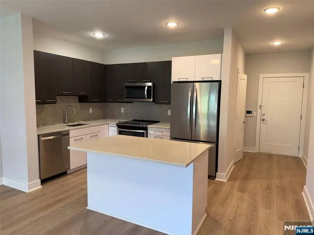 a kitchen with stainless steel appliances a refrigerator and a stove top oven
