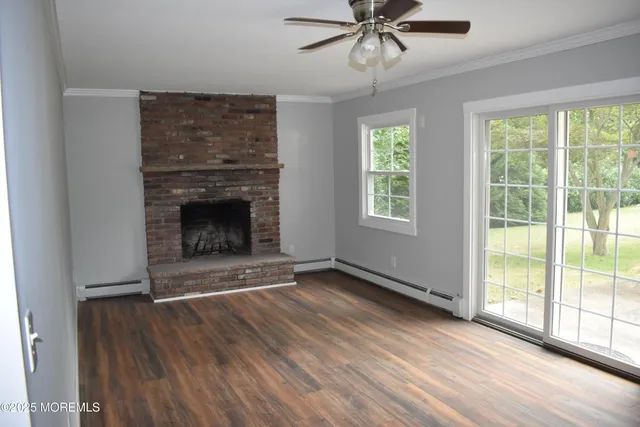 wooden floor fireplace and windows in an empty room