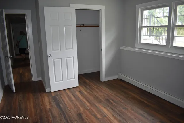 an empty room with wooden floor and closet