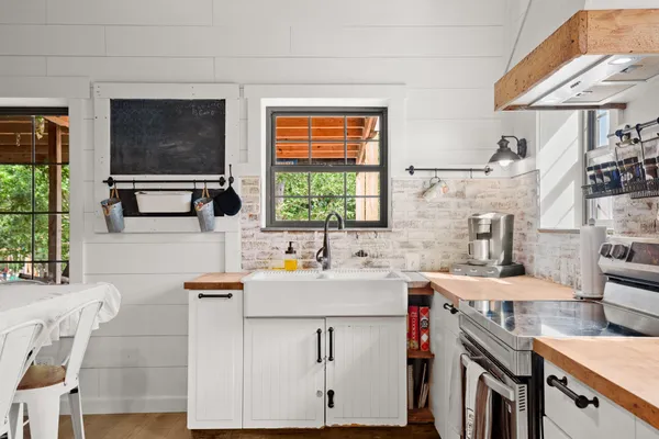 a kitchen that has a sink a stove and a table