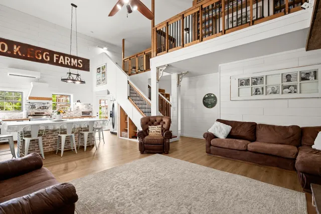 a living room with furniture kitchen view and a large window