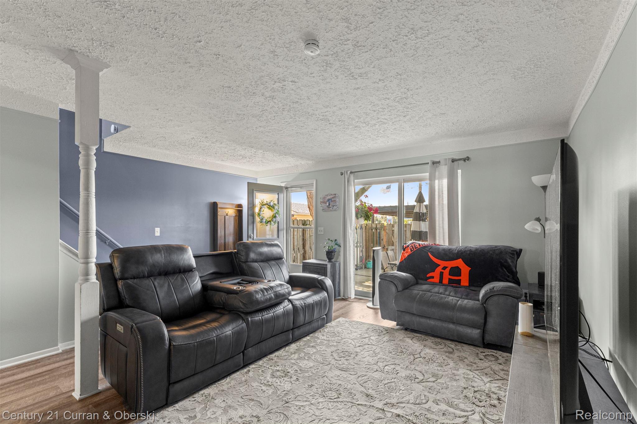 31083 Hoover Road, Unit 12 Warren, MI 48093 - Photo 12 of 39 Spacious living area featuring wood-finish flooring, light blue and accent gray walls, and white trim