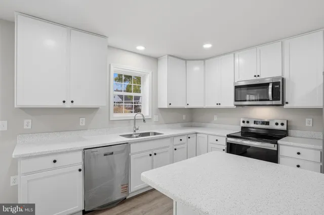 a kitchen with a sink a stove and cabinets