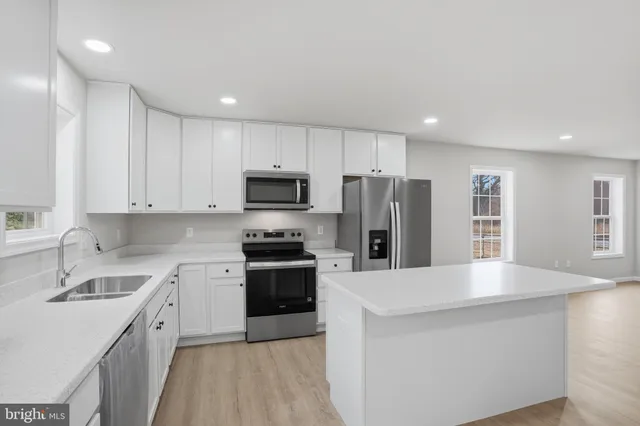 a kitchen with stainless steel appliances a refrigerator sink and microwave