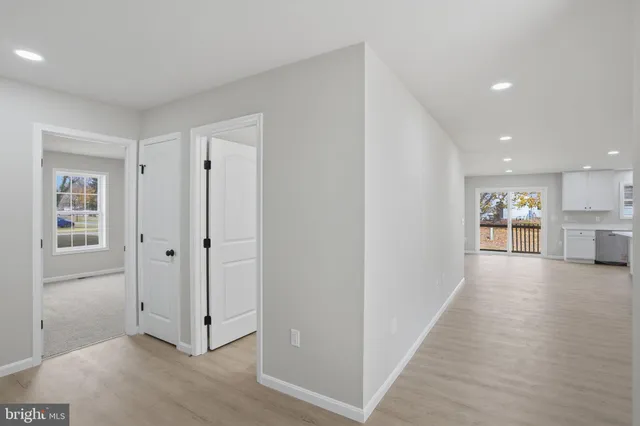 a view of a hallway with wooden floor and kitchen