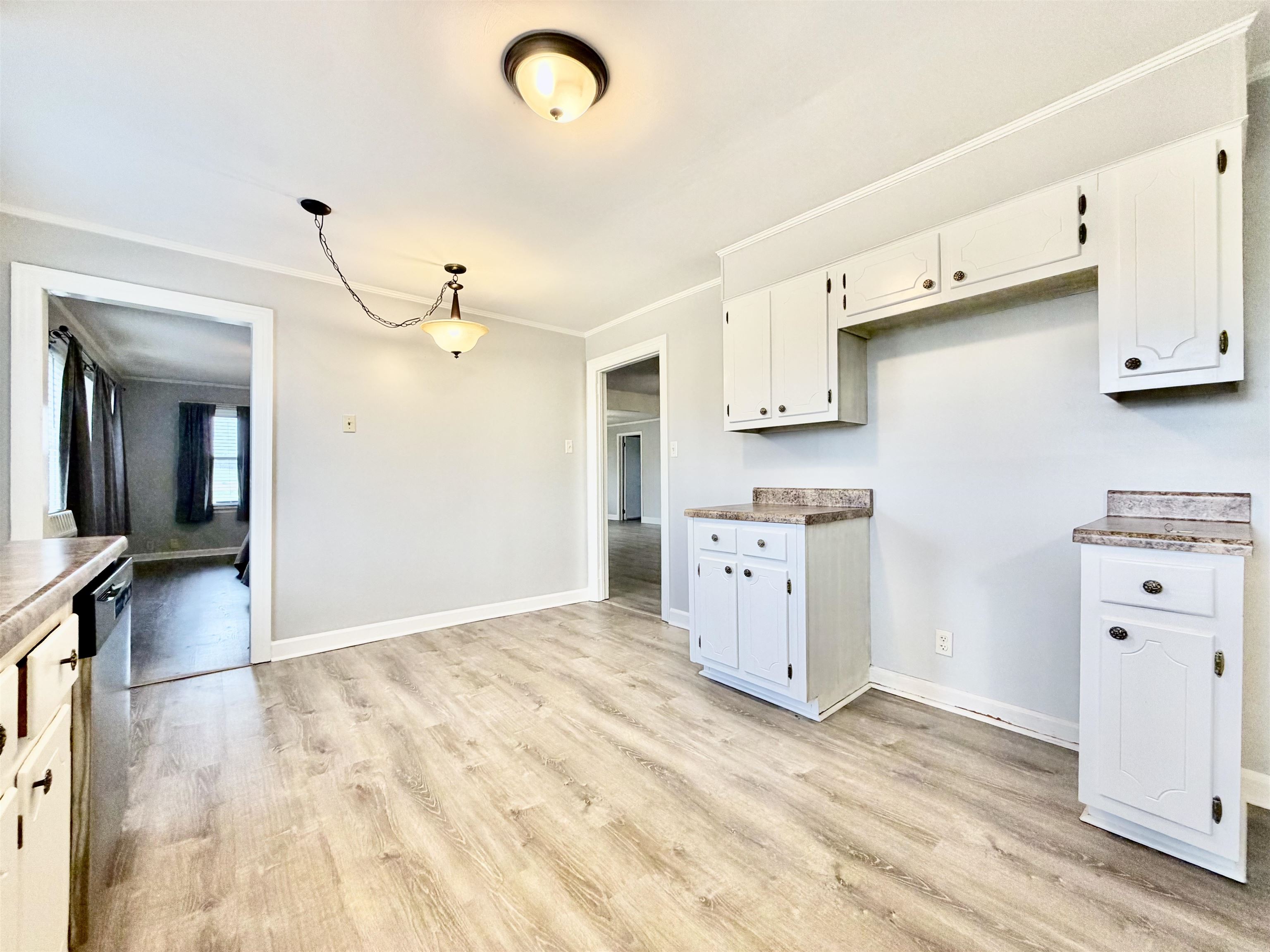 5442 Bride Road Covington, TN 38019 - Photo 11 of 19 Kitchen featuring ornamental molding, white cabinets, light wood-style floors, dishwasher, and hanging light fixtures