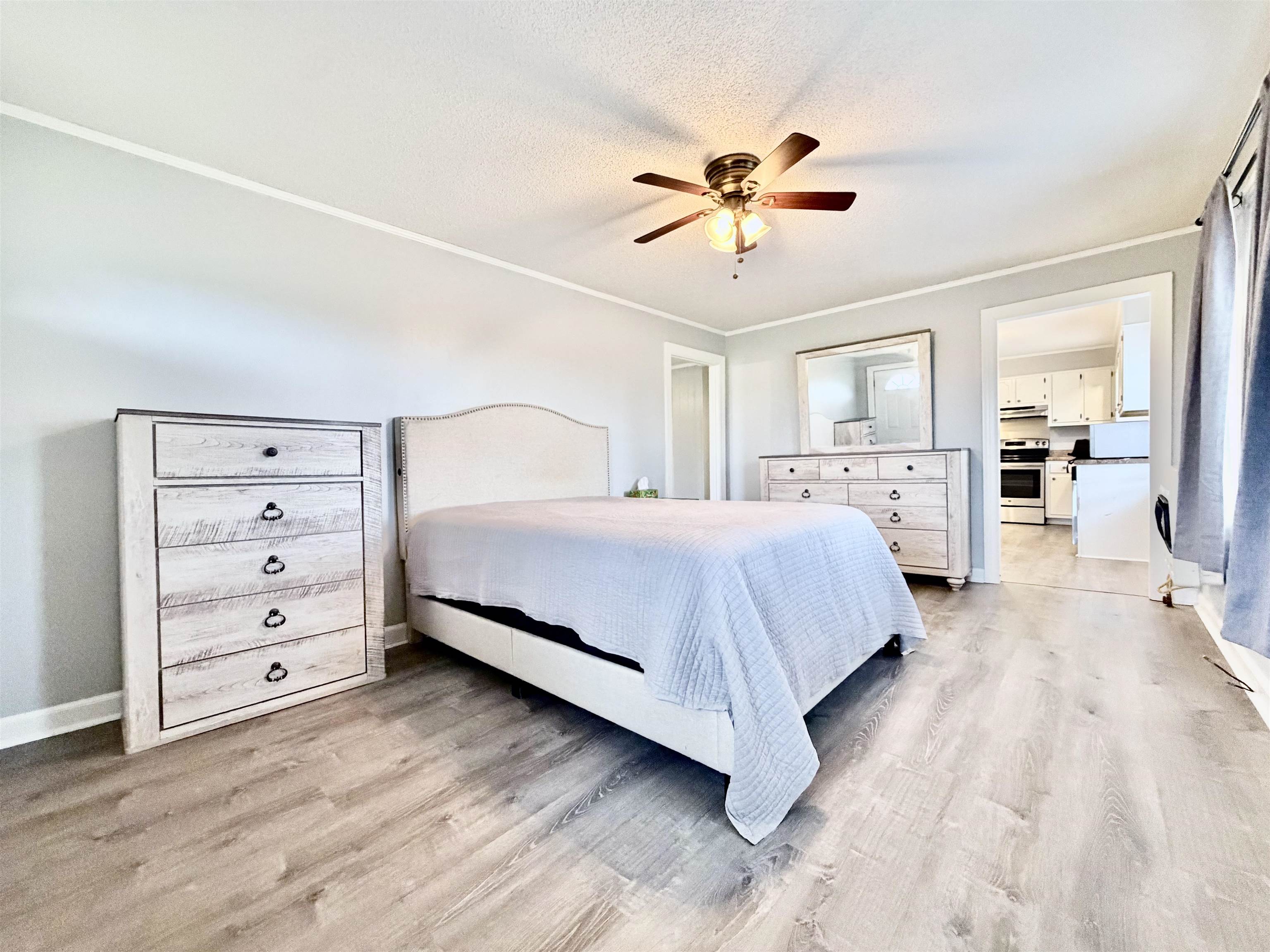 5442 Bride Road Covington, TN 38019 - Photo 14 of 19 Bedroom featuring ceiling fan, light wood-type flooring, crown molding, and a textured ceiling