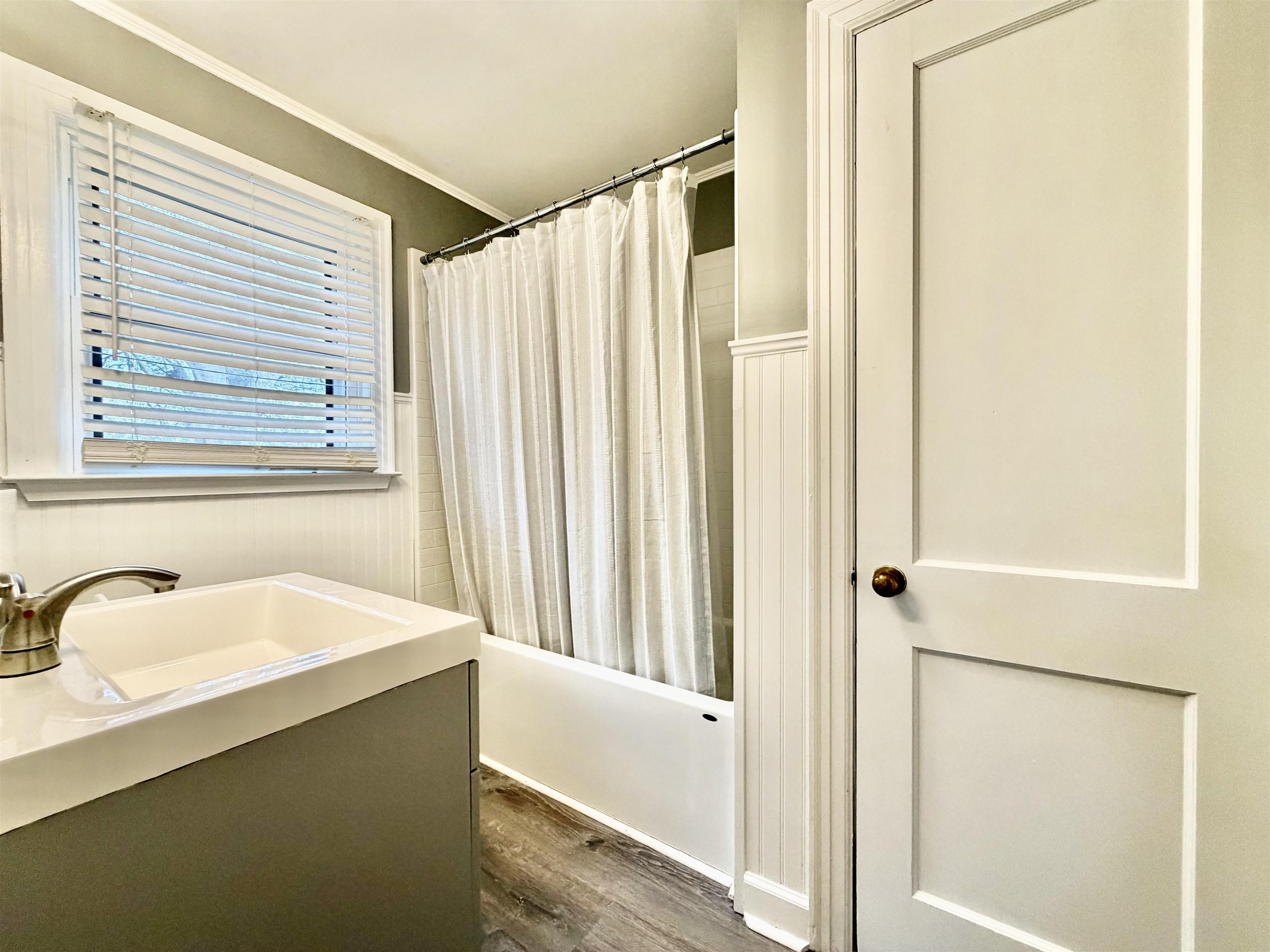 5442 Bride Road Covington, TN 38019 - Photo 16 of 19 Bathroom with a wainscoted wall, vanity, dark wood finished floors, shower / tub combo, and ornamental molding