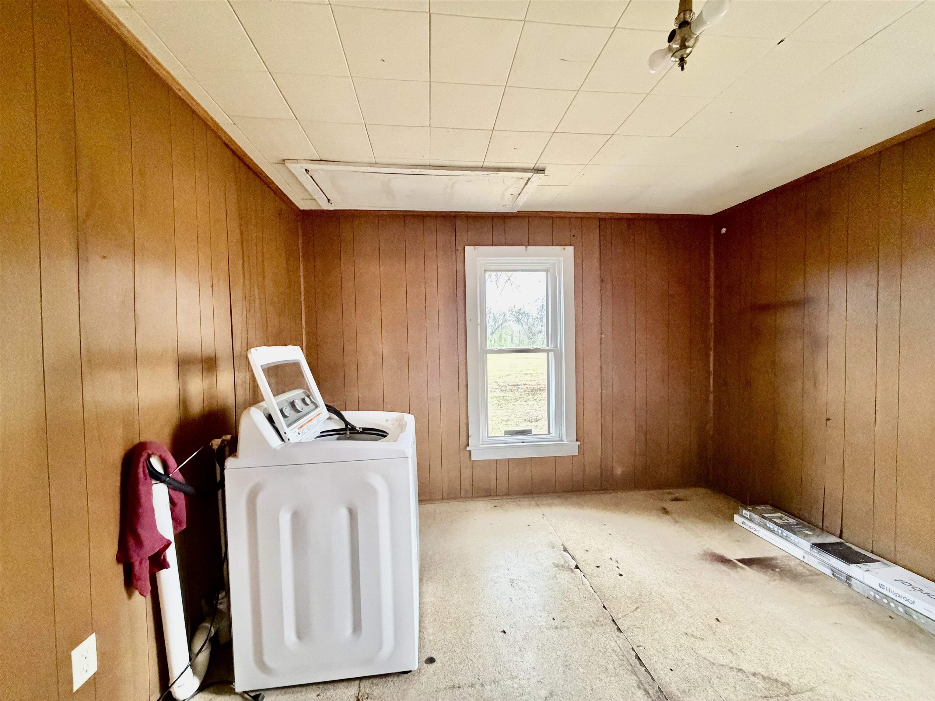 5442 Bride Road Covington, TN 38019 - Photo 18 of 19 Laundry area featuring washing machine and clothes dryer and wooden walls