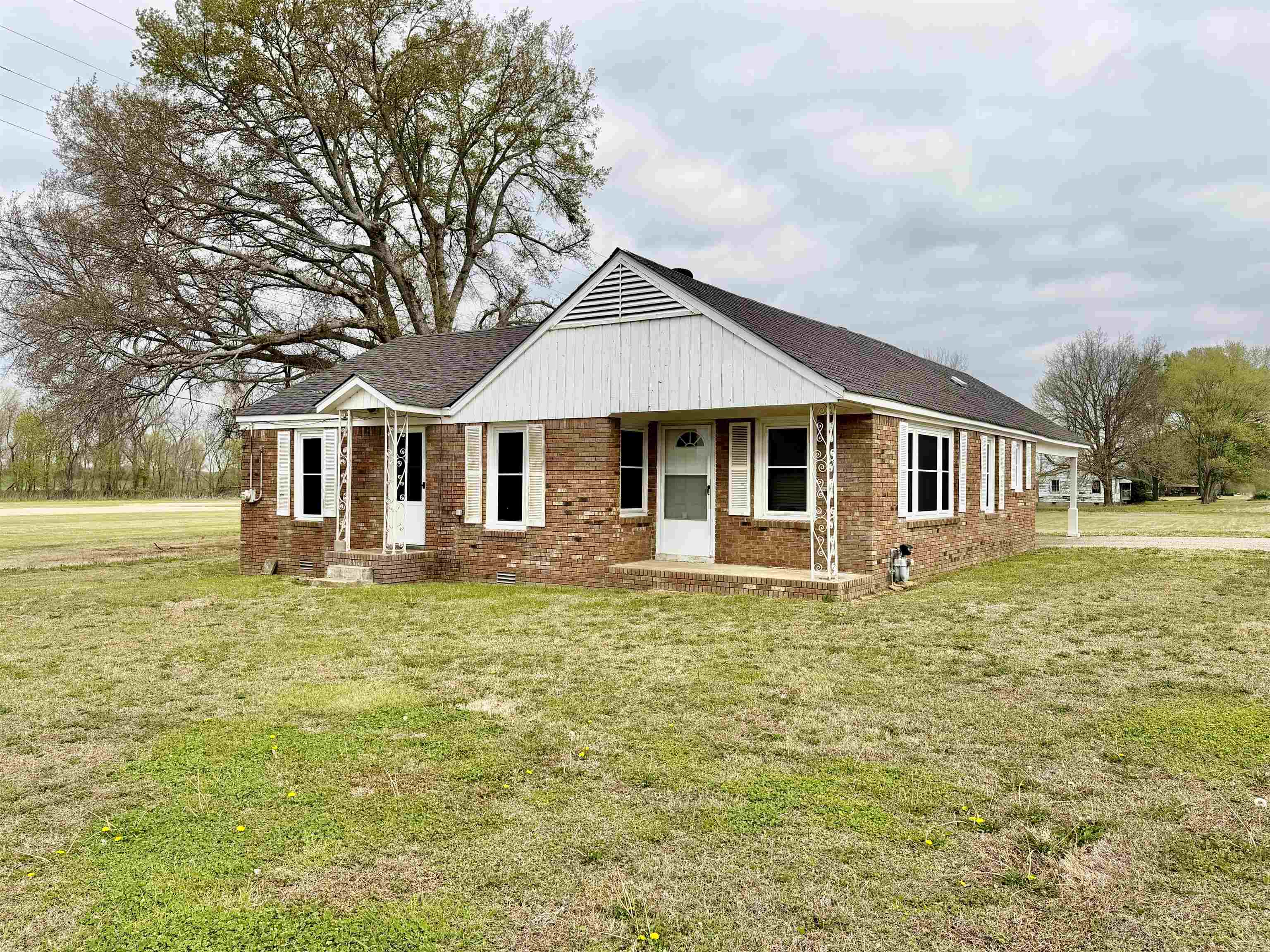 5442 Bride Road Covington, TN 38019 - Photo 3 of 19 View of front of home featuring brick siding, a front lawn, and covered porch