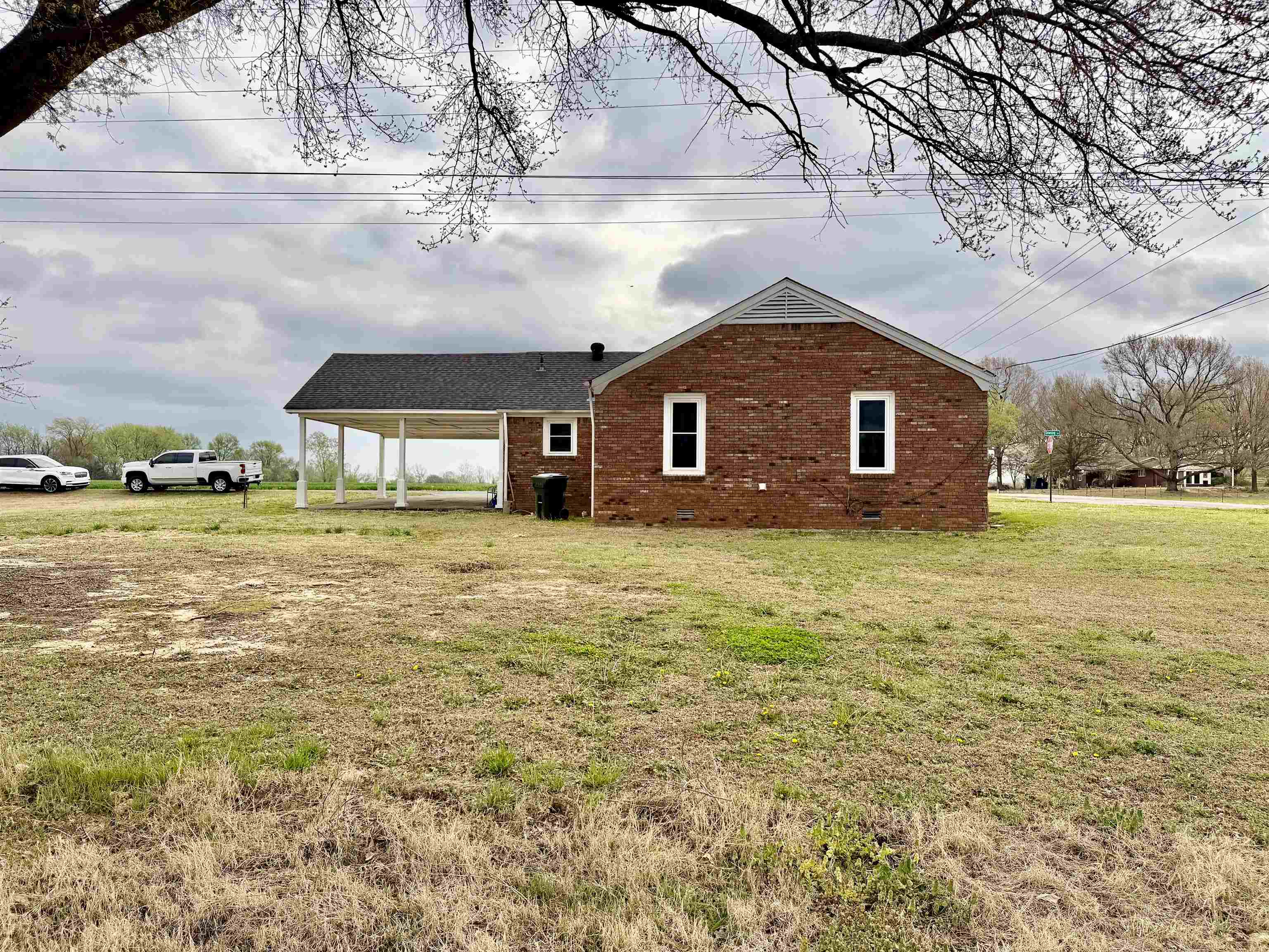 5442 Bride Road Covington, TN 38019 - Photo 5 of 19 View of side of property featuring brick siding, a yard, and an attached carport