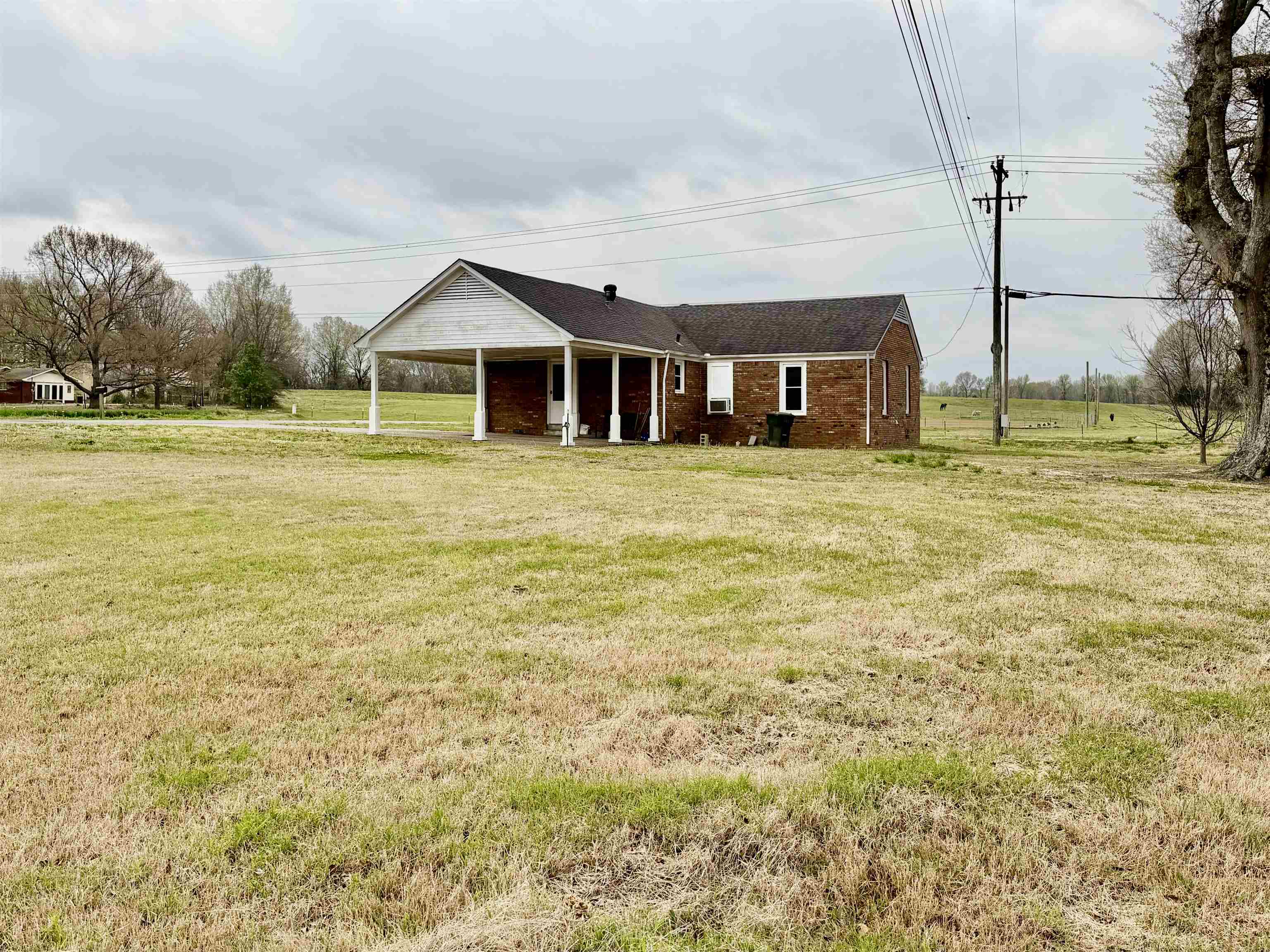 5442 Bride Road Covington, TN 38019 - Photo 6 of 19 View of front of house featuring a carport, a front lawn, brick siding, and covered porch