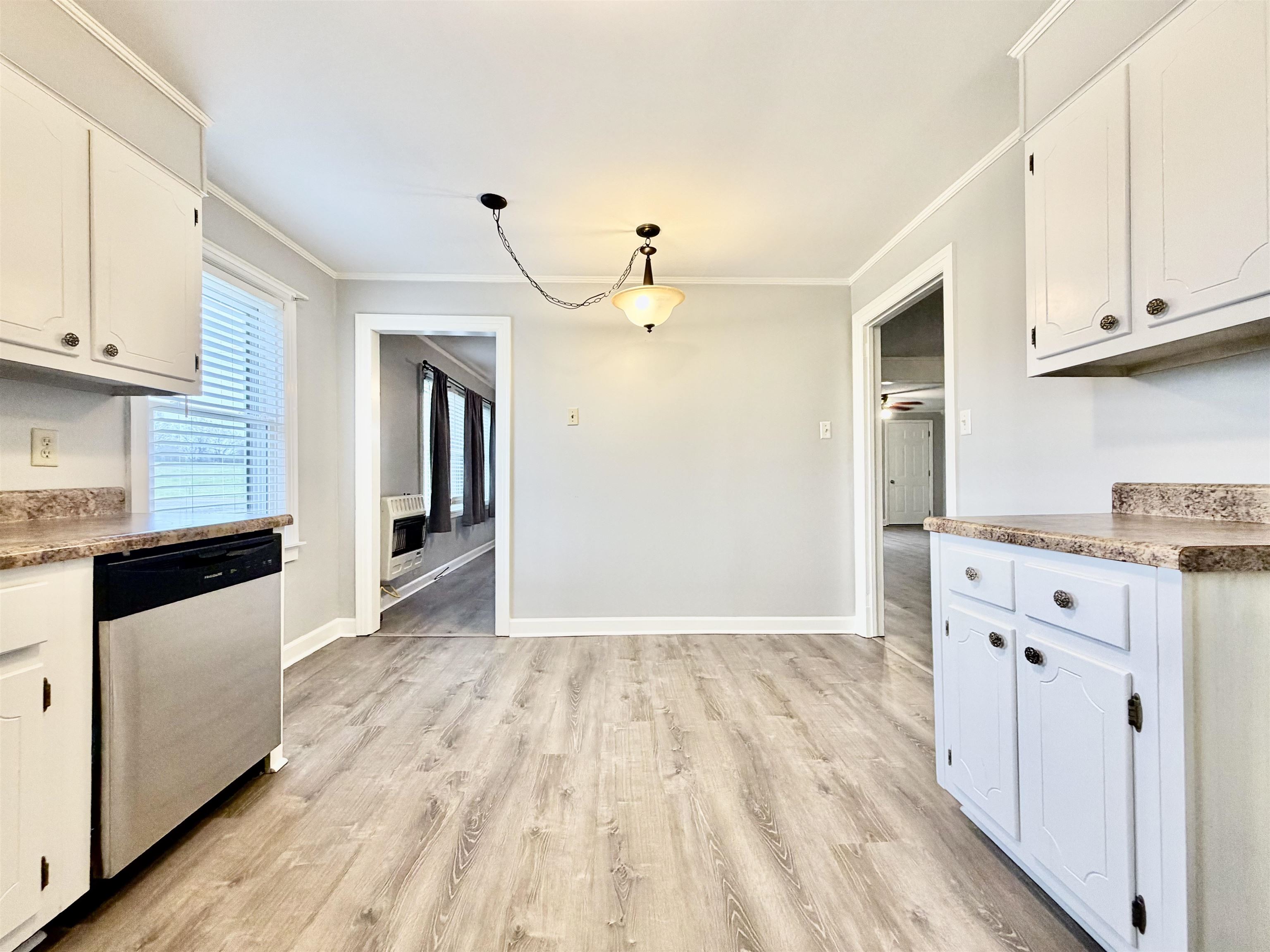 5442 Bride Road Covington, TN 38019 - Photo 10 of 19 Kitchen with white cabinetry, light wood-style floors, stainless steel dishwasher, ornamental molding, and heating unit