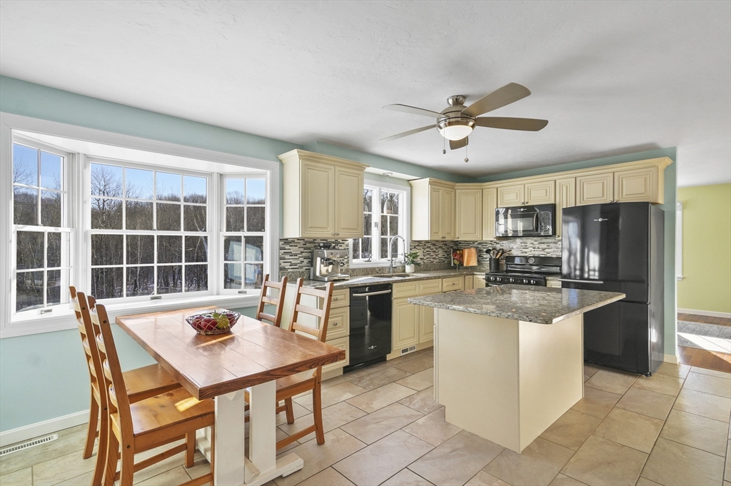 56 Glenwood Road Rutland, MA 01543 - Photo 5 of 41 a kitchen with stainless steel appliances granite countertop a table chairs and a refrigerator