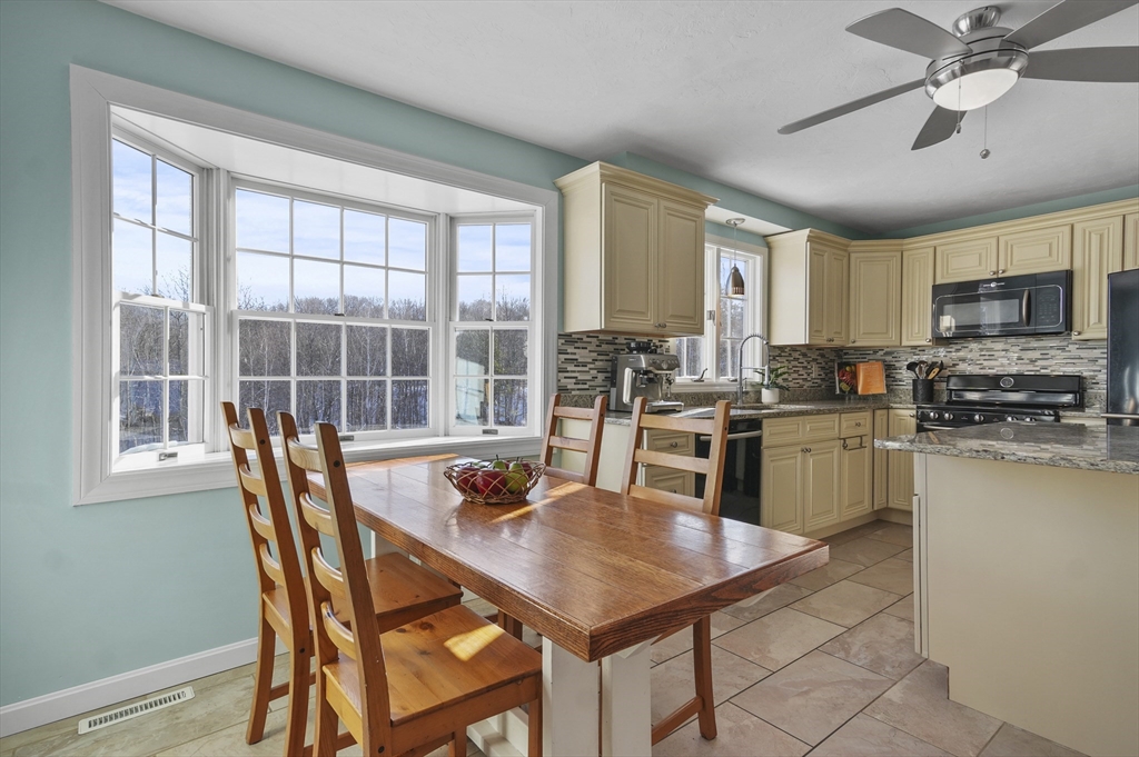 56 Glenwood Road Rutland, MA 01543 - Photo 8 of 41 a kitchen with stainless steel appliances granite countertop a stove a refrigerator a kitchen island a table and chairs