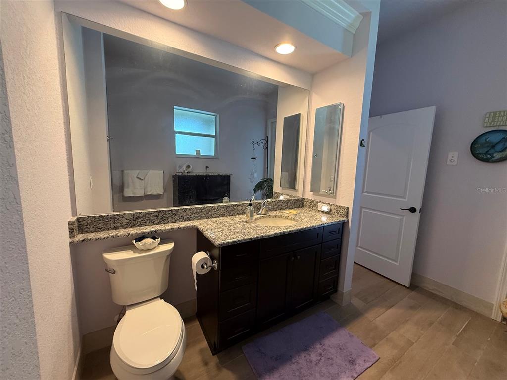 13110 Bamboo Street Spring Hill, FL 34609 - Photo 33 of 56 a bathroom with a granite countertop toilet sink and mirror