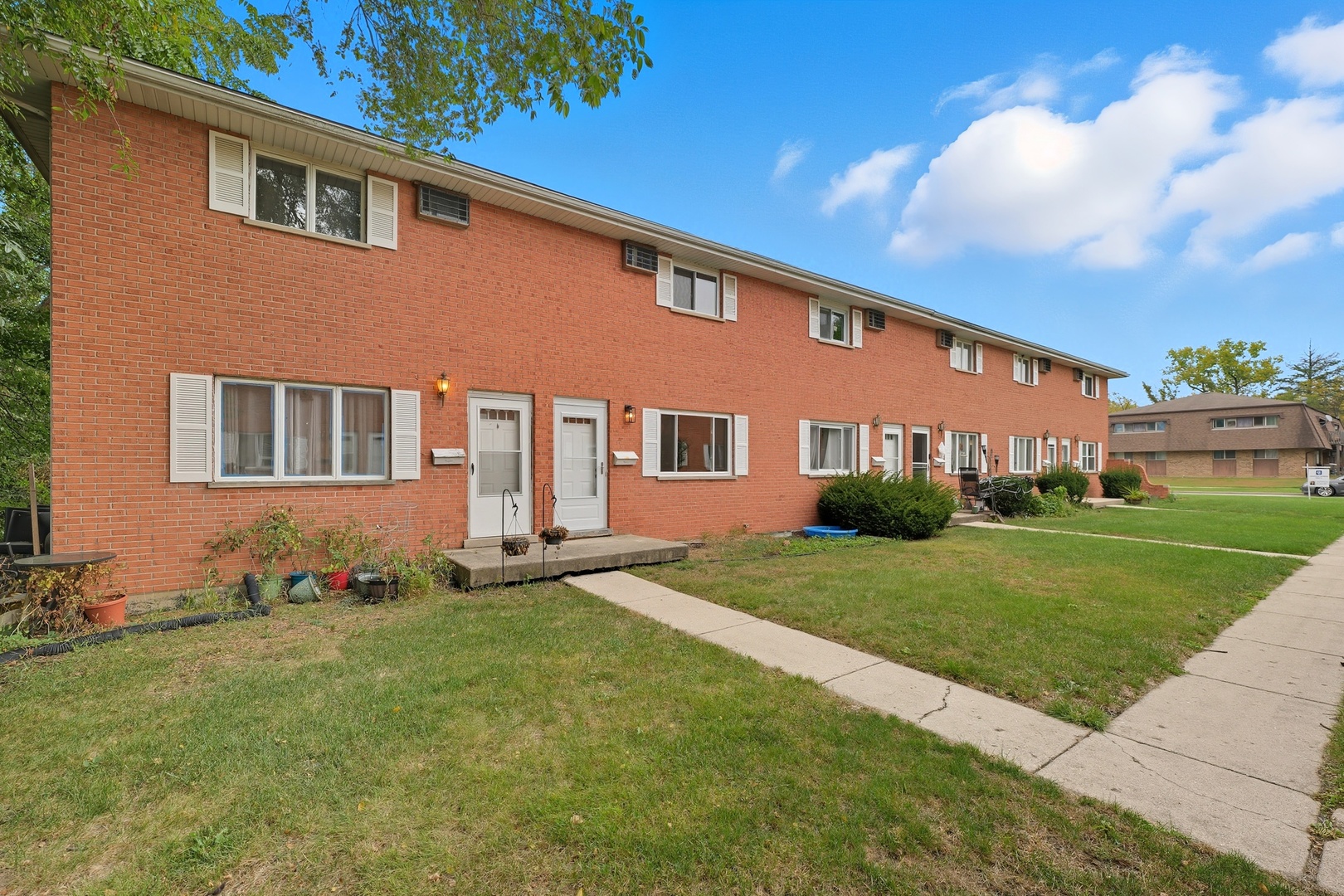 1231 Town Crest Drive, Unit E New Lenox, IL 60451 - Photo 2 of 15 a front view of a house with a garden