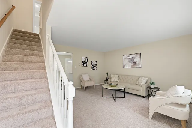 a living room with furniture and stairs
