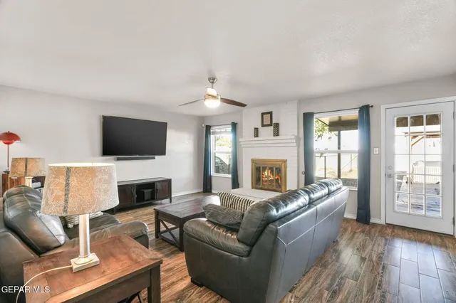 a living room with furniture a flat screen tv and a fireplace