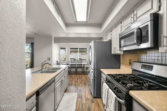 a kitchen with granite countertop a sink stove and refrigerator