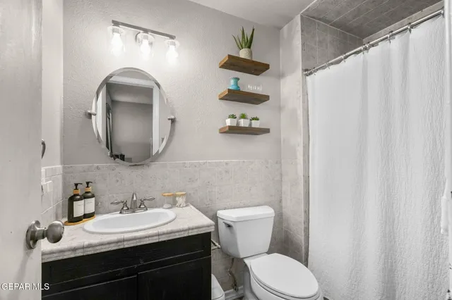a bathroom with a toilet a sink and a mirror