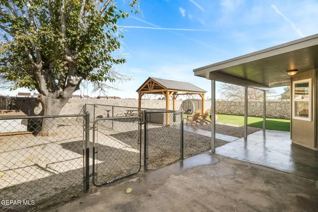 a view of yard with table and chairs and potted plants