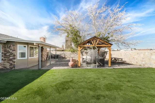 a view of a house with a yard and sitting area
