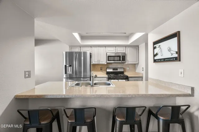 a kitchen with a table chairs refrigerator and cabinets