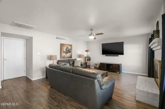 a living room with furniture and a wooden floor