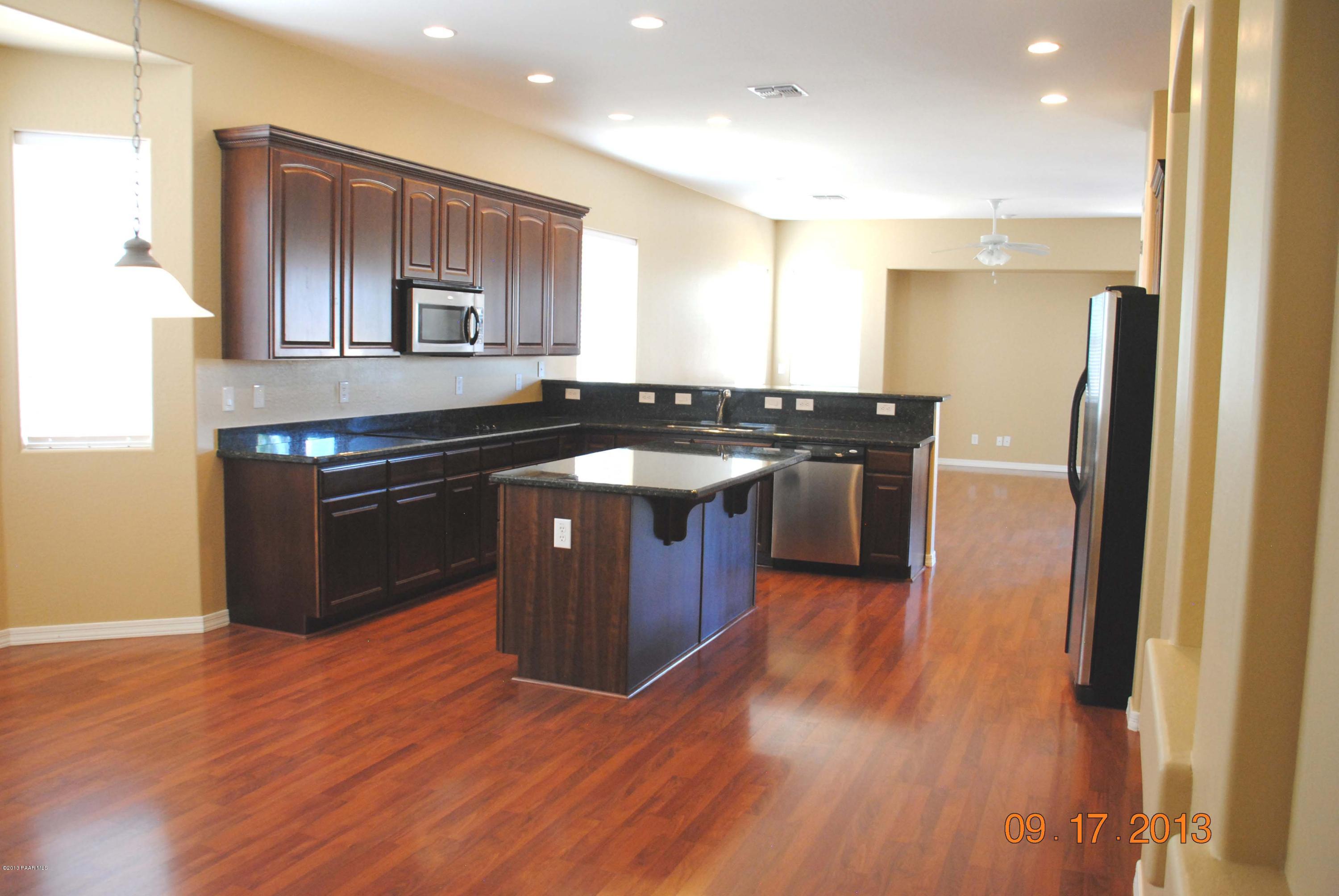 7906 East Mesteno Road Prescott Valley, AZ 86315 - Photo 2 of 24 a kitchen with stainless steel appliances granite countertop wooden floors and sink