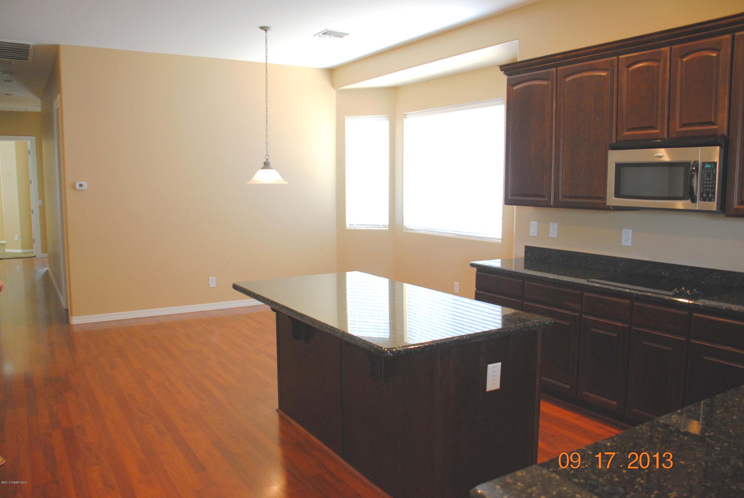 7906 East Mesteno Road Prescott Valley, AZ 86315 - Photo 3 of 24 a kitchen with granite countertop a refrigerator and a stove