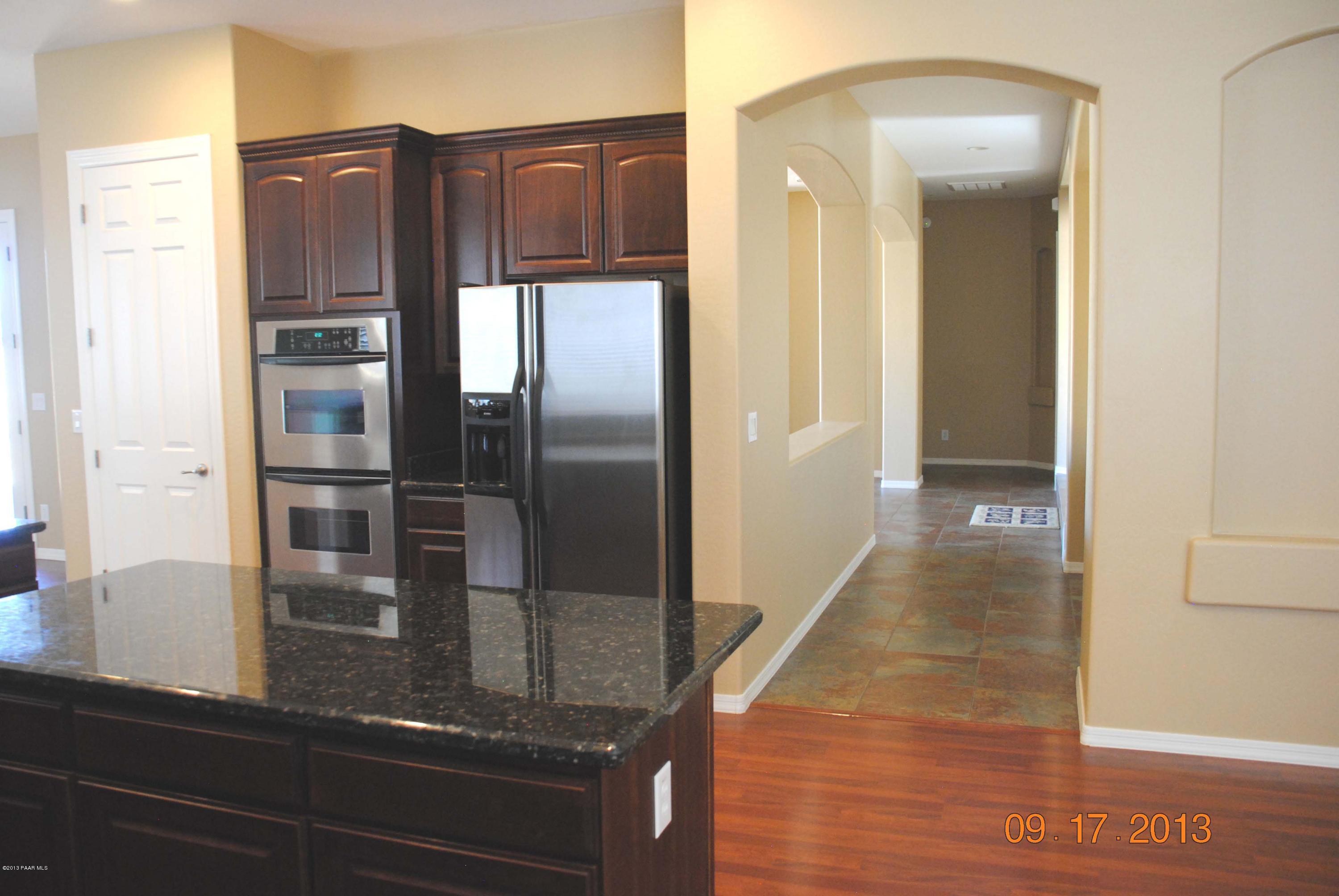 7906 East Mesteno Road Prescott Valley, AZ 86315 - Photo 4 of 24 a kitchen with granite countertop a refrigerator and a sink