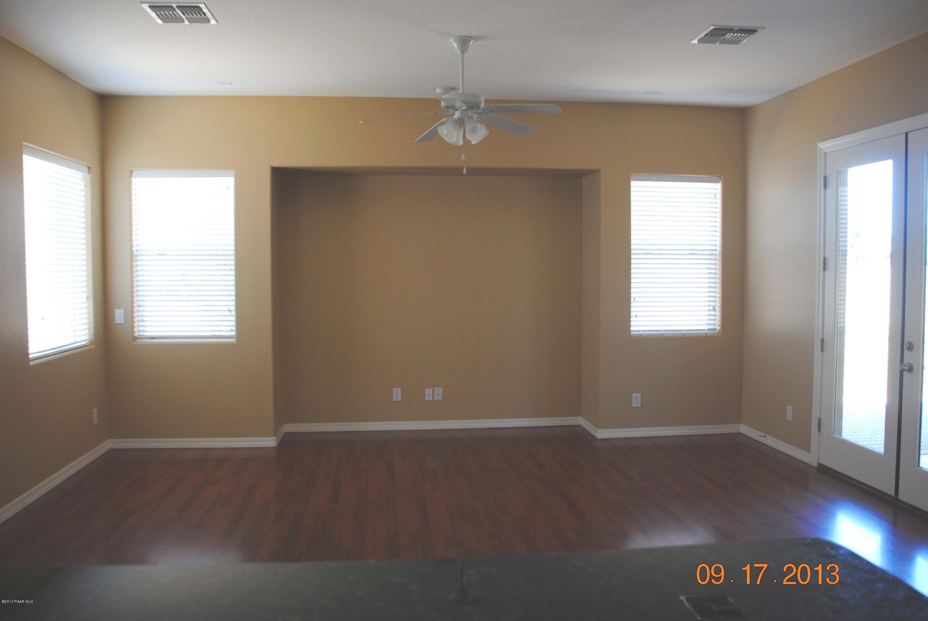 7906 East Mesteno Road Prescott Valley, AZ 86315 - Photo 8 of 24 an empty room with wooden floor and windows